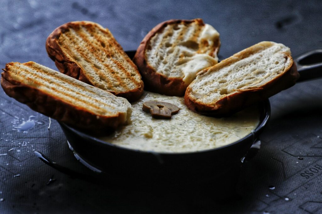 A creatively styled bowl of cheese and bread, highlighting an artistic food presentation.