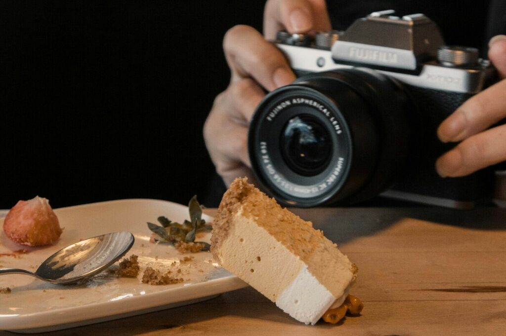 A person photographing a slice of cake, showcasing food photography techniques and vibrant dessert details.