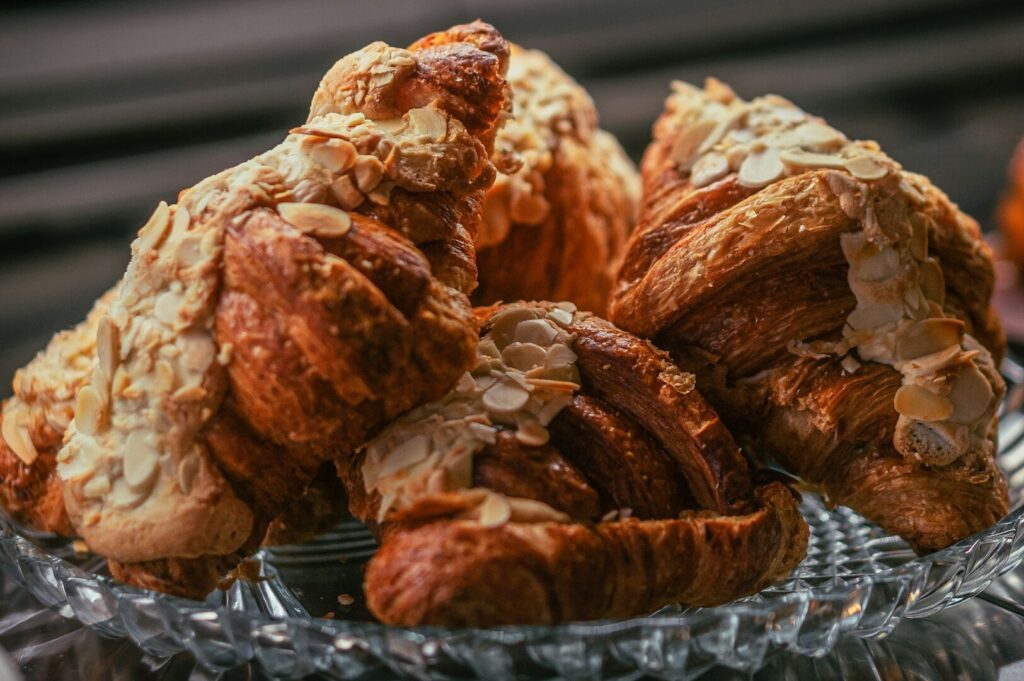 A close-up of a glass plate filled with freshly baked croissants, showcasing their buttery layers and inviting color.