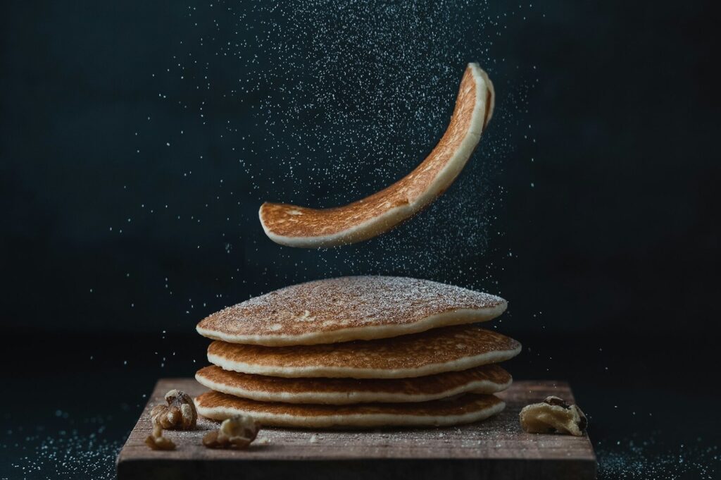 A surreal scene of pancakes raining down, illustrating creative food photography techniques.
