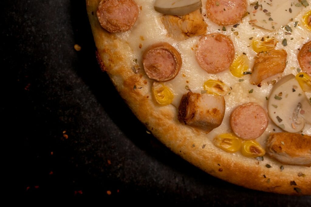 A delicious pizza featuring sausage and corn toppings, captured in a detailed food photography style.