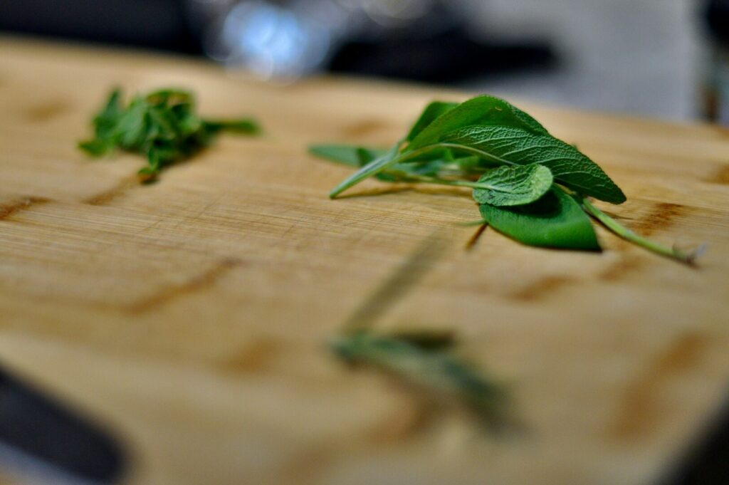 A knife placed beside vibrant herbs on a cutting board, captured in a professional food photography style.