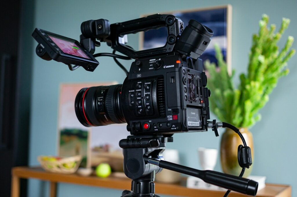A camera mounted on a tripod facing a blue painting, prepared for a professional food photography session.