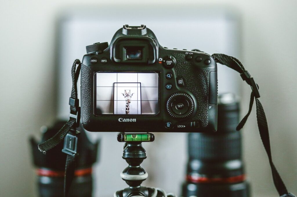 A professional food photography setup featuring a camera on a tripod with a lens attached.