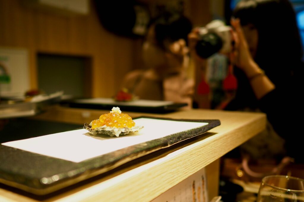 A woman capturing a close-up of a food dish, showcasing her skills in professional food photography.