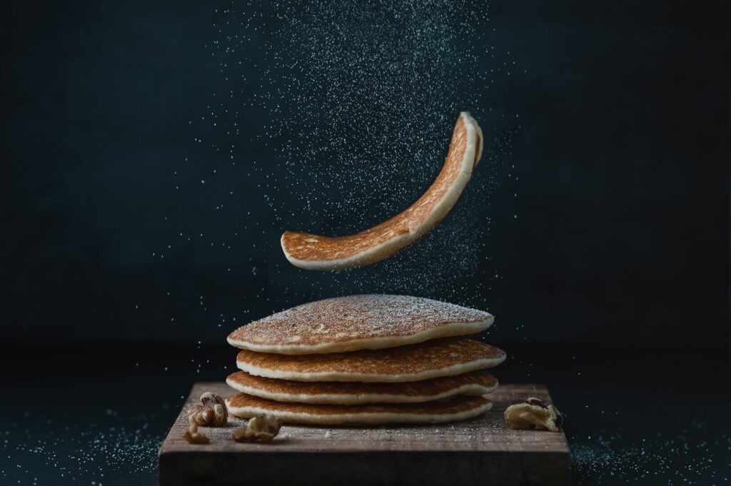 A surreal scene of pancakes raining down, showcased in vibrant food photography.