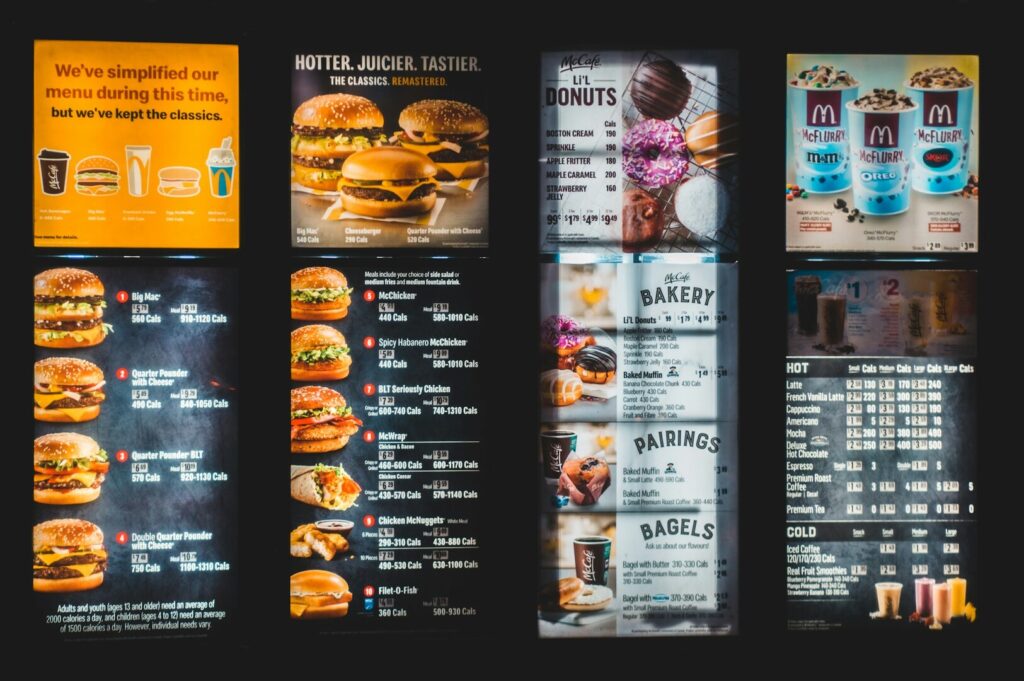 A menu featuring a variety of burgers and drinks, showcasing food photography and design elements.