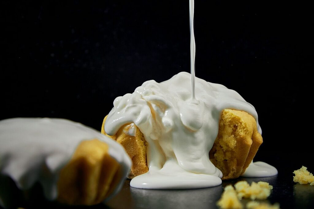A close-up of a muffin topped with glossy icing, showcasing intricate details in food art photography.