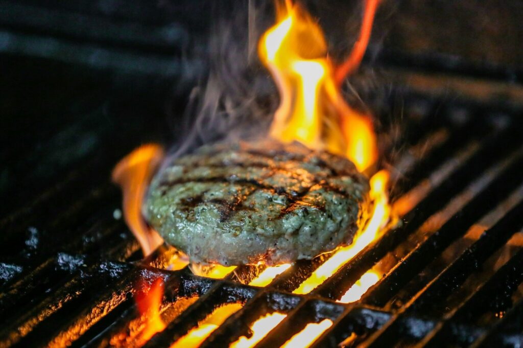 A juicy hamburger being grilled, highlighting the vibrant culinary scene in Singapore.
