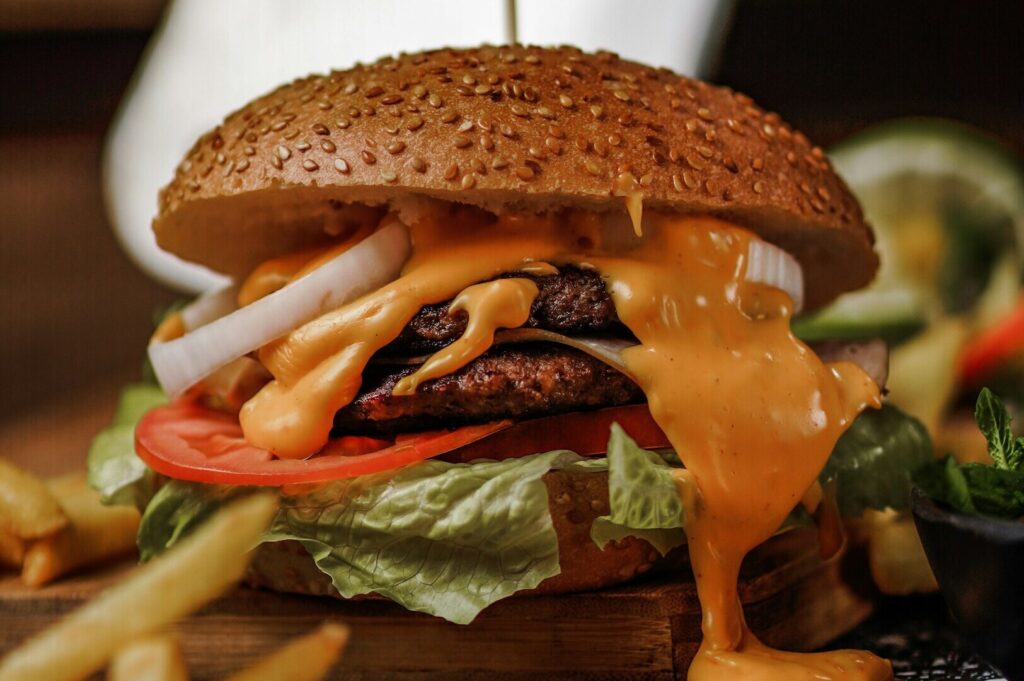 A delicious hamburger featuring layers of cheese and crisp lettuce, captured in an appealing food photography style.