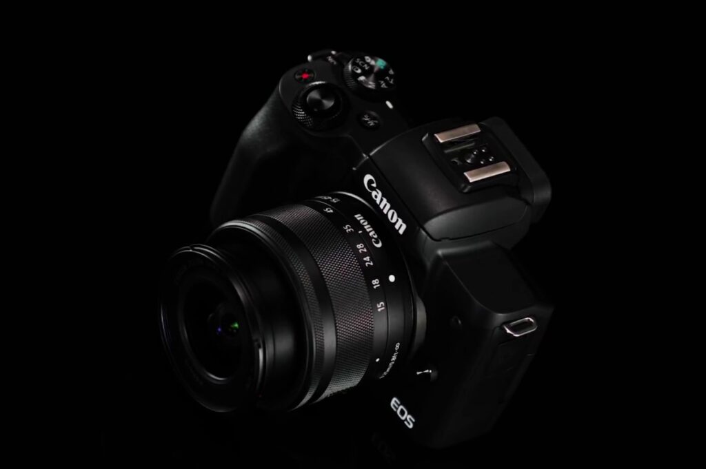 A sleek black Canon EOS camera with a large lens is displayed against a dark background, highlighting its modern design and intricate details.
