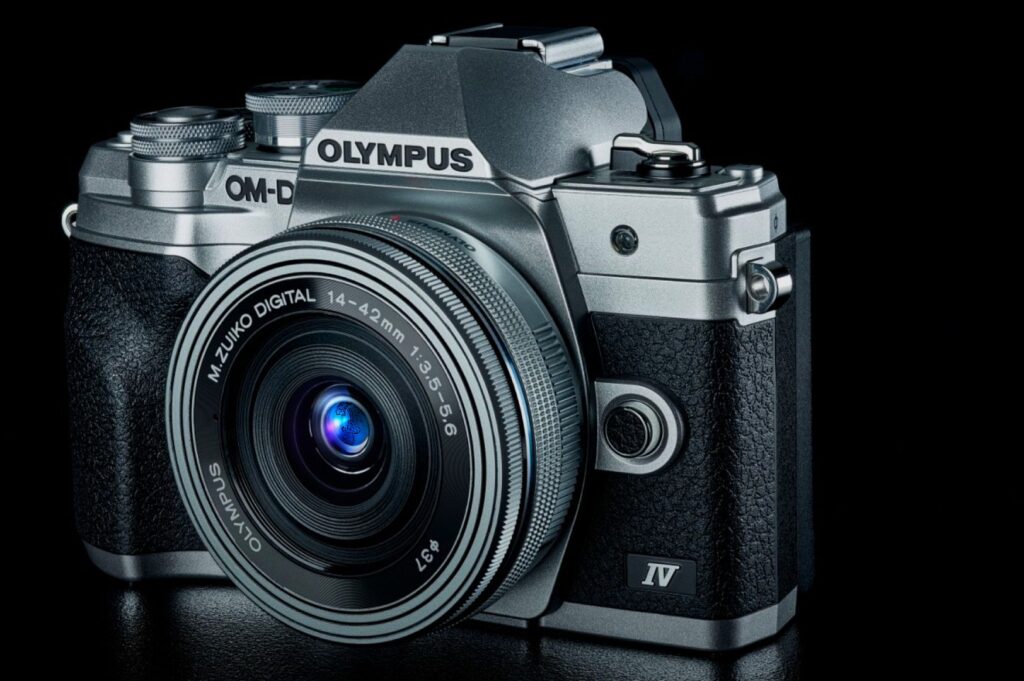 Retro-style Olympus OM-D camera on a black background. Features textured grip, prominent lens with branding, conveying precision and elegance.