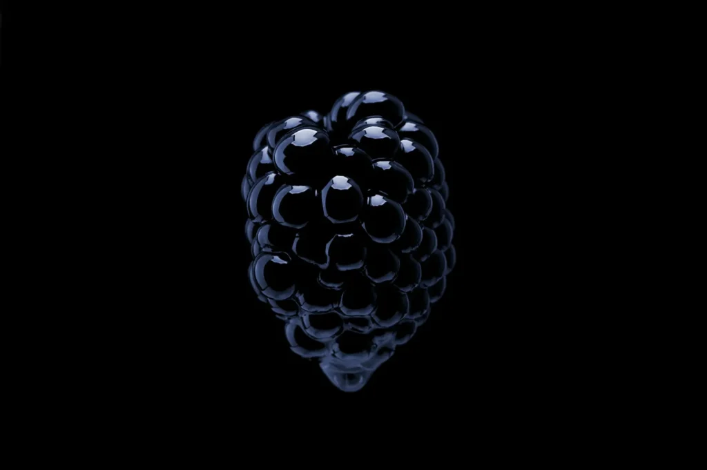 “Close-up of a single blackberry against a black background. The berry is glossy and dark, highlighting its smooth, round drupelets. Elegant and striking.”
