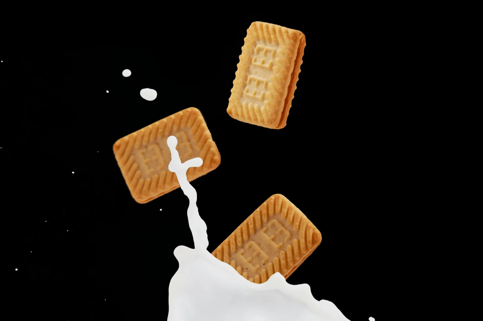 Three rectangular biscuits are falling into a splashing pool of milk against a black background, creating a dynamic and playful scene.