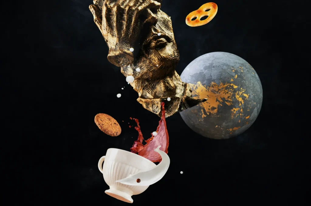 A surreal image featuring a textured golden bust above a white cup spilling red liquid. Floating cookies and a moon with gold accents appear against a dark background.