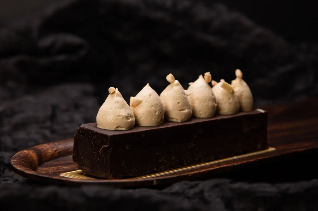 Smooth and creamy chocolate dessert pastry with piped cream topping.