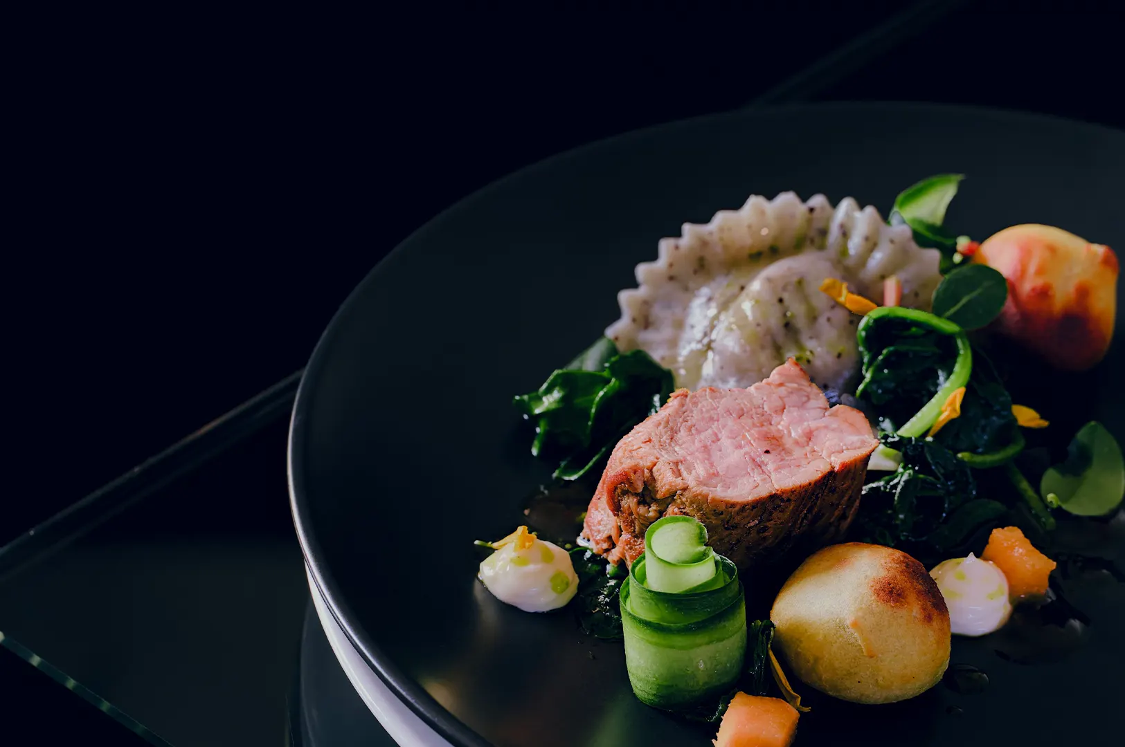 Professional food photography of a high-end culinary dish on a black plate with empty space for restaurant branding.