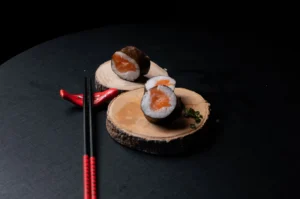 Salmon sushi maki rolls on wooden boards, 45-degree angle food photography shot.