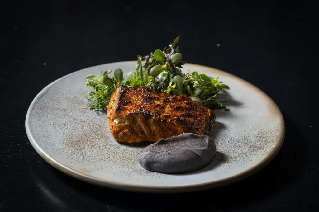 Dark moody food photography of a plated heritage dish with dark background.