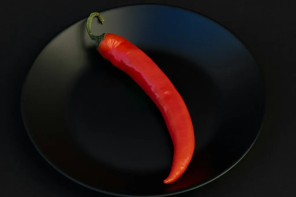 Red chili pepper on a black plate.