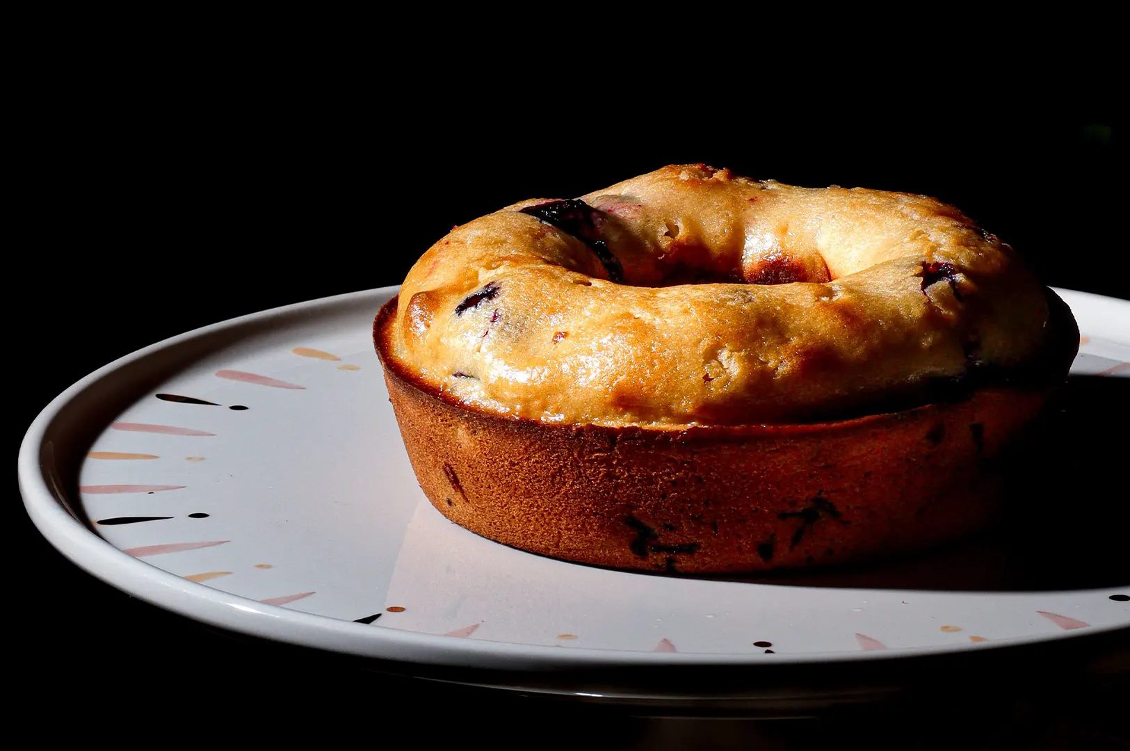 Freshly baked pastry on a plate with dark moody lighting.