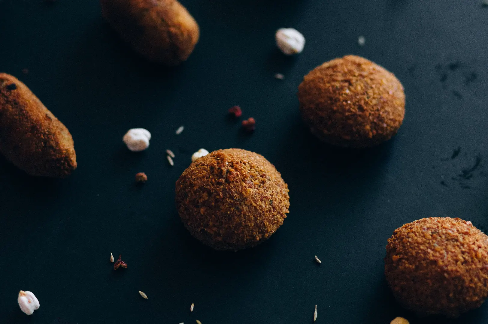 Dark moody food photography of corporate catering finger food on a black background.