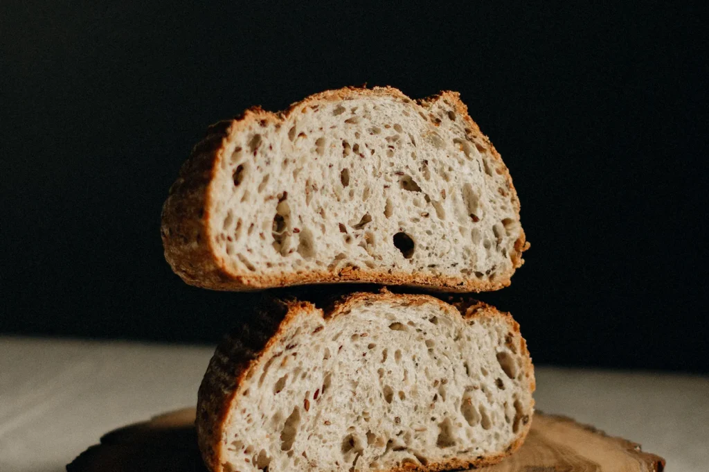 Cross-section of freshly sliced artisan bread showing crumb texture on dark background.