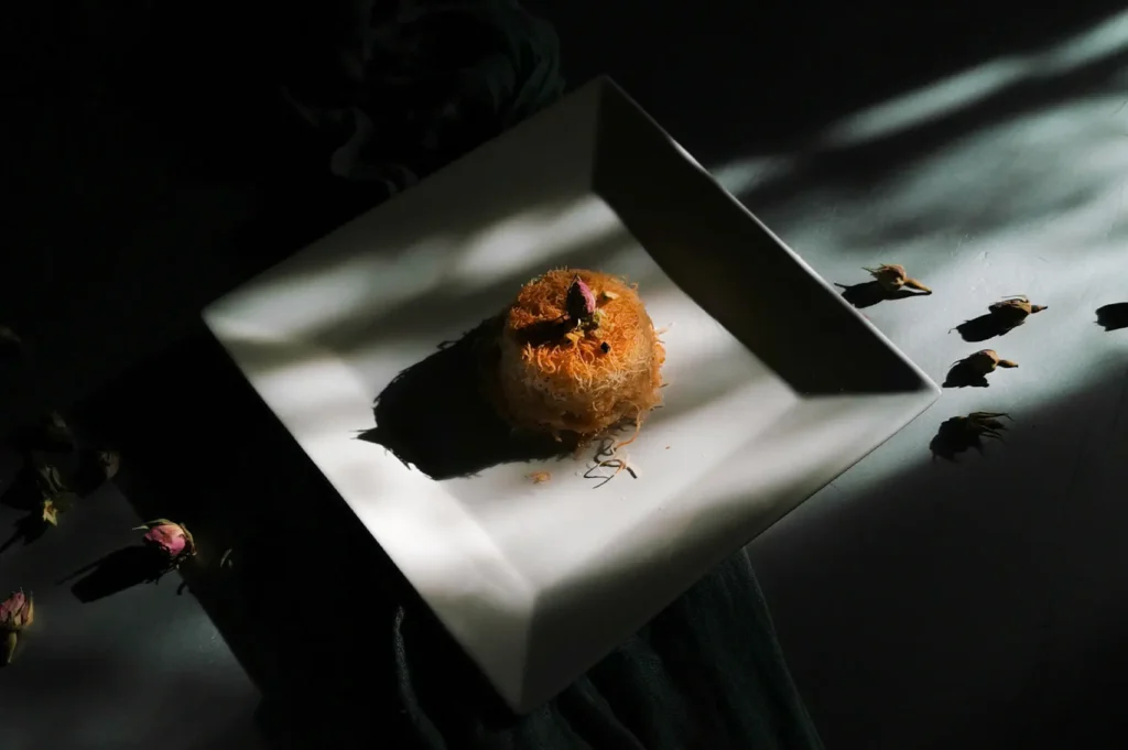 Individual meal portion served on a square white plate with dark moody food photography styling.