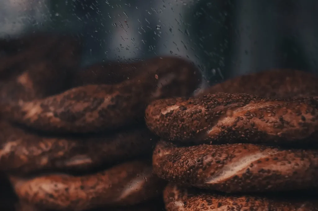 Freshly baked pastries displayed behind a glass cabinet with reflections.