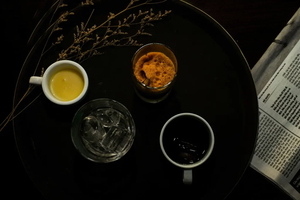 Dark and moody hotel room service coffee tray with drinks.