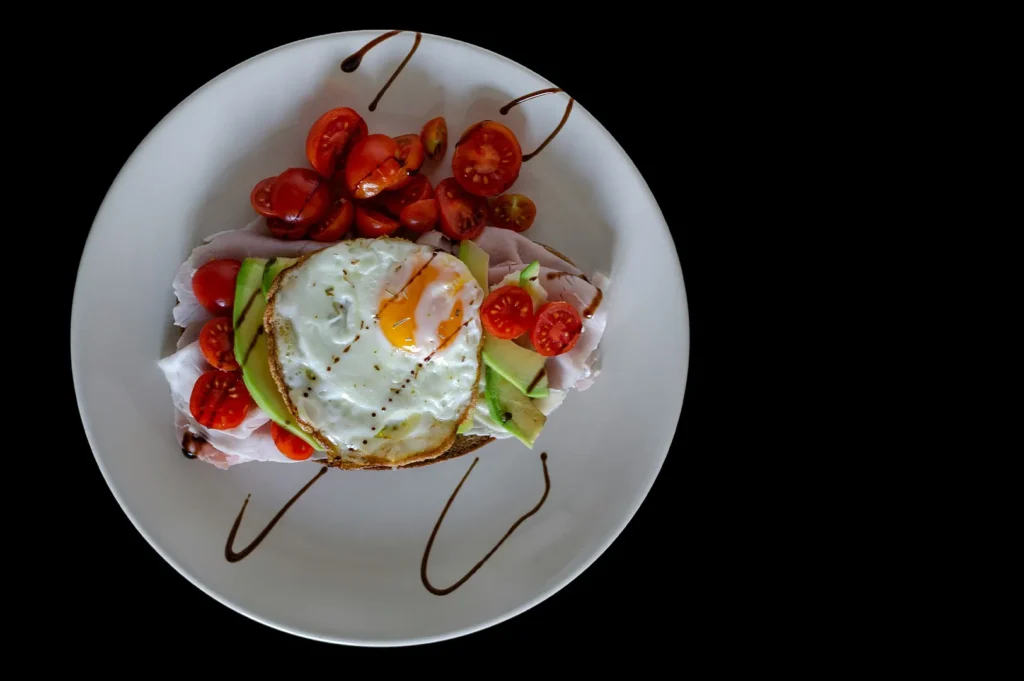 Simple kids meal plate with egg and vegetables on a dark background.